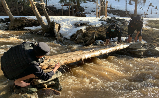 2020年4月18日，民警正在加固过河的木桥。张家旭 摄